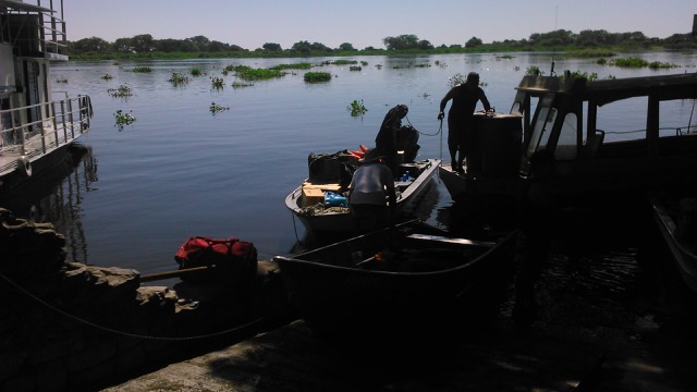 Barcos da Ecoa e da Universidade Federal do MS saem de Corumbá em direção à Serra do Amolar. Ao fundo o rio Paraguai em tempo de águas altas, transportando camalotes. Muitos irão bater no rio da Prata.
