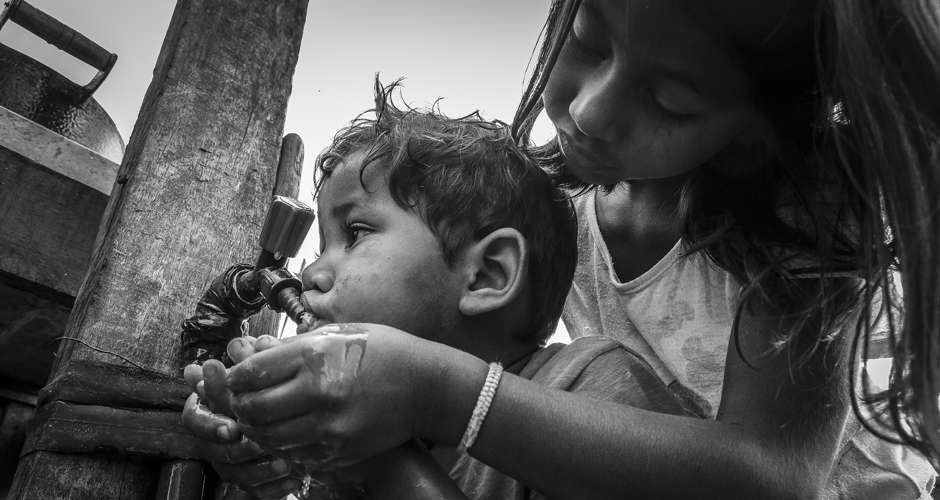 crianças bebem água tratada em aldeia indígena